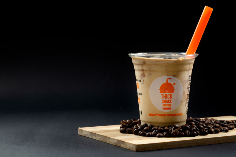 TTSF cold coffee on a board of roasted beans